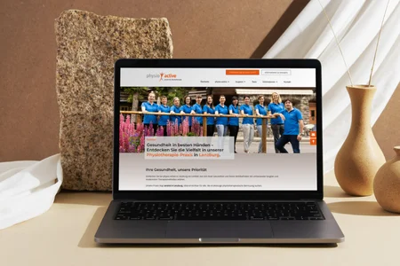 Website von PhysioActive Lenzburg auf einem Laptop – moderne Physiotherapie-Webseite mit Teamfoto und Leistungsübersicht.