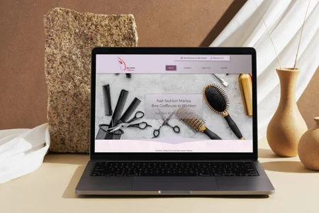 Website eines Coiffeursalons in Wohlen mit Friseurwerkzeug im Design – dargestellt auf einem Laptop.